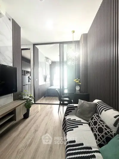 Modern living room with stylish decor and open layout, featuring a cozy seating area and elegant lighting.