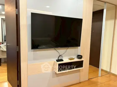 Modern living room with wall-mounted TV and sleek wooden flooring