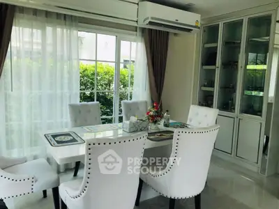 Elegant dining area with white chairs and large window view