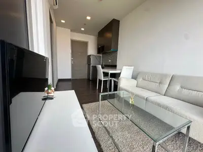 Modern living room with sleek furniture and open kitchen layout in a stylish apartment.