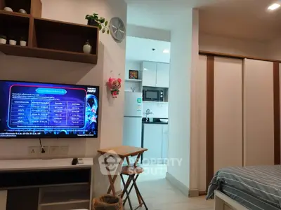 Modern studio apartment with open layout, featuring a cozy living area and compact kitchen.