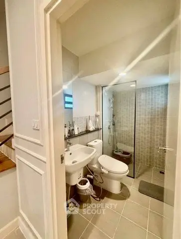 Modern bathroom with glass shower and sleek fixtures in a stylish home.