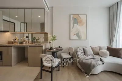 Modern open-layout living room with cozy seating and stylish kitchen area.