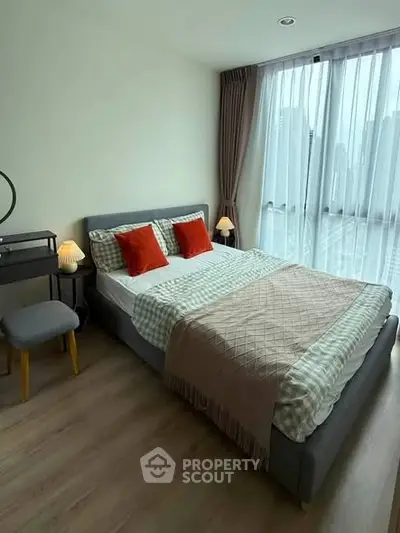 Modern bedroom with city view, featuring stylish decor and ample natural light.
