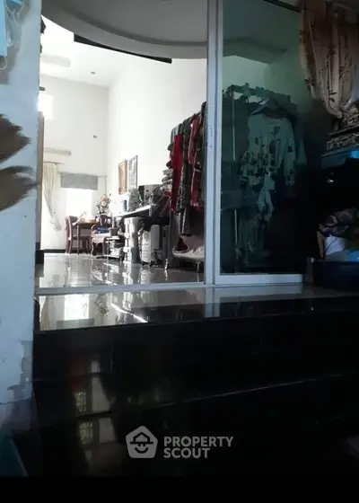 Spacious interior with dining area and clothing storage, featuring glossy black flooring.