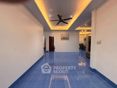 Spacious modern living room with blue tile flooring and ceiling fan