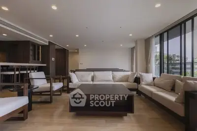 Spacious modern living room with elegant furniture and large windows offering natural light.
