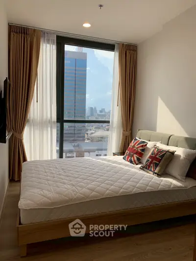 Modern bedroom with city view, featuring stylish decor and large windows for natural light.