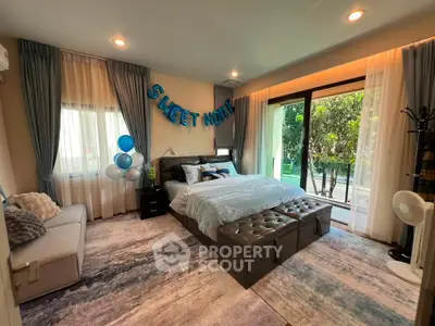 Luxurious bedroom with elegant decor and garden view, featuring plush bedding and stylish furnishings.