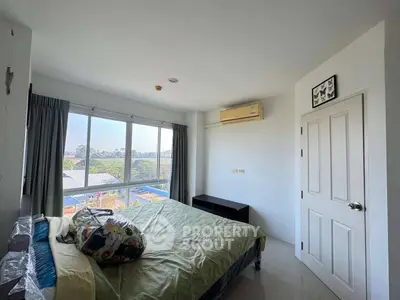 Bright bedroom with large window and scenic view, featuring air conditioning and minimalist decor.