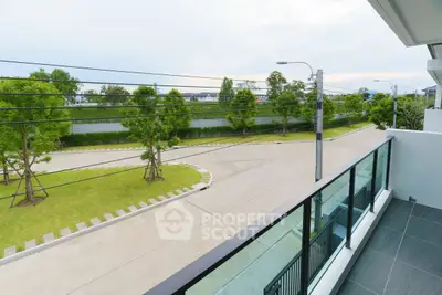 Spacious balcony with serene street view in modern residential area.