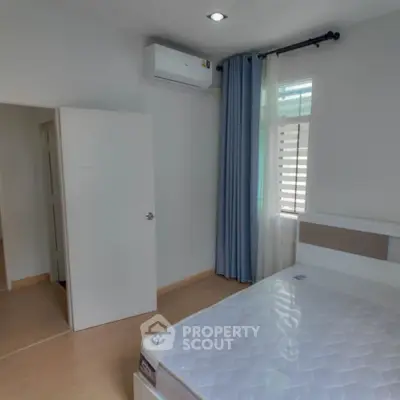 Modern bedroom with air conditioning and natural light, featuring a comfortable bed and sleek design.