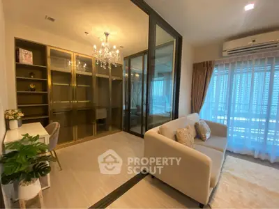 Luxurious living room with elegant chandelier and glass partition, featuring cozy sofa and stylish decor.