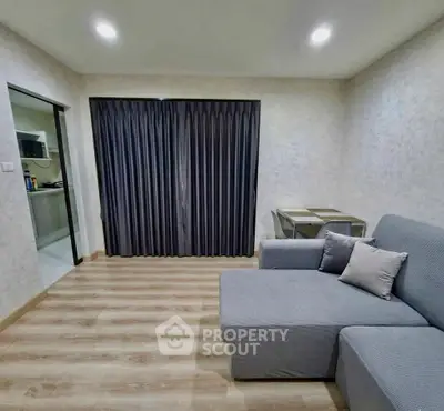 Modern living room with cozy gray sofa and elegant curtains in a stylish apartment.