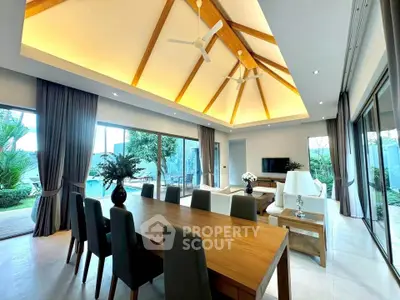 Luxurious open-plan living room with high ceilings and pool view.