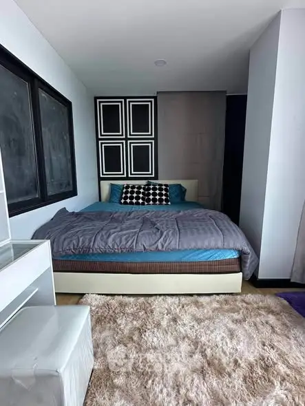 Modern bedroom with stylish decor and cozy ambiance, featuring a plush bed and soft carpet.