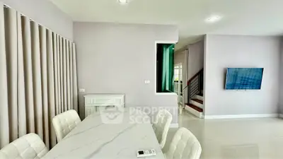 Modern dining area with elegant marble table and wall-mounted TV in a stylish home interior.