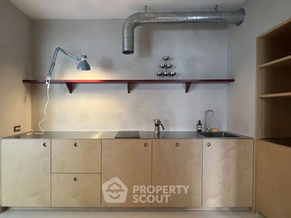 Modern minimalist kitchen with sleek cabinetry and industrial lighting