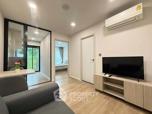 Modern living room with sleek design, featuring air conditioning and a view into the bedroom.