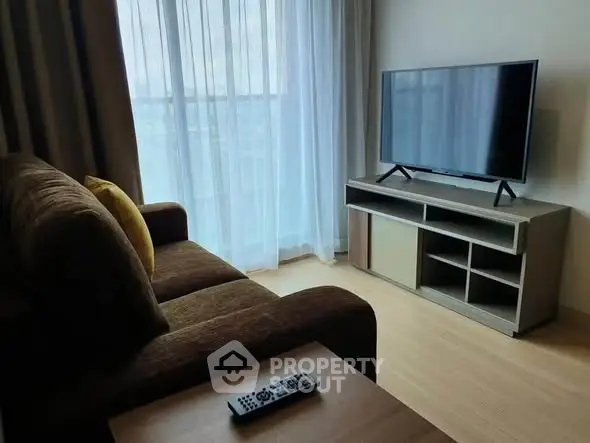 Cozy living room with modern TV setup and plush sofa, perfect for relaxation.