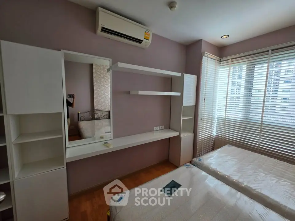 Modern bedroom with air conditioning and large windows in a stylish apartment.