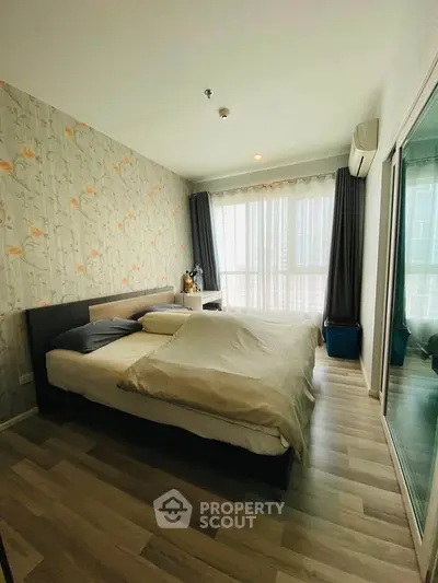 Spacious bedroom with modern decor and large windows offering natural light.
