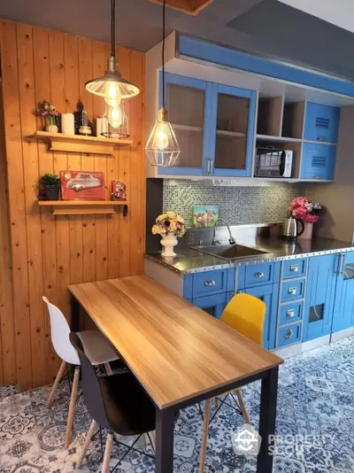 Charming kitchen with blue cabinets and stylish lighting, perfect for modern living.