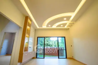 Spacious modern living room with elegant ceiling design and large sliding glass doors opening to a garden view.
