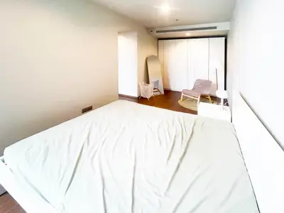 Spacious bedroom with modern decor and ample natural light, featuring a large bed and stylish furnishings.