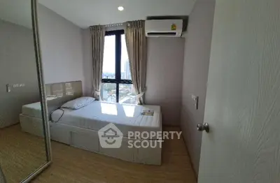 Cozy bedroom with city view, mirrored wardrobe, and air conditioning in modern apartment.