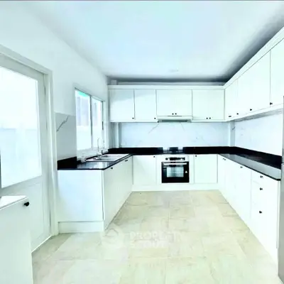 Modern white kitchen with sleek cabinets and black countertops