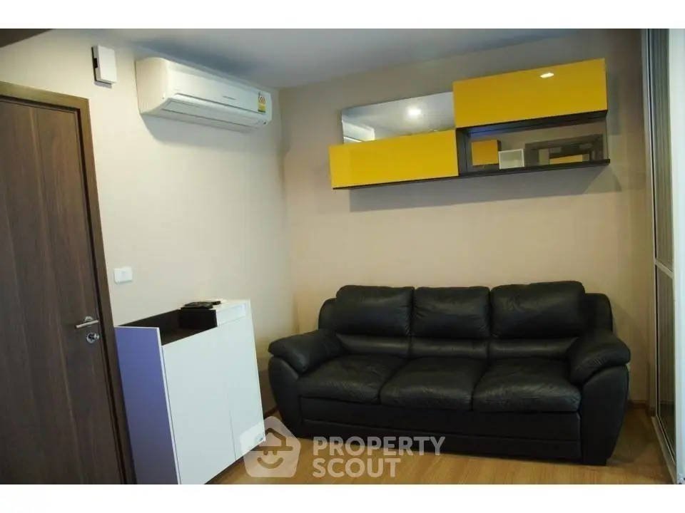 Modern living room with black leather sofa and stylish yellow shelving.