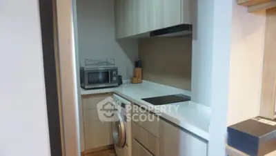 Modern kitchen with sleek cabinetry, washing machine, and built-in appliances.
