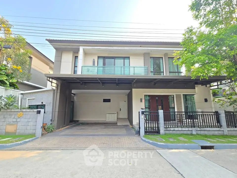 Modern two-story house with spacious driveway and balcony in a serene neighborhood.