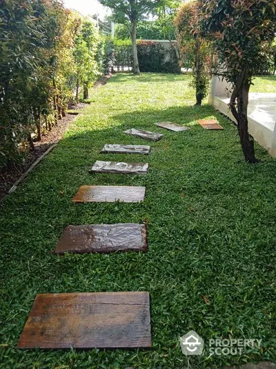 Charming garden pathway with lush greenery and stepping stones, perfect for serene outdoor living.