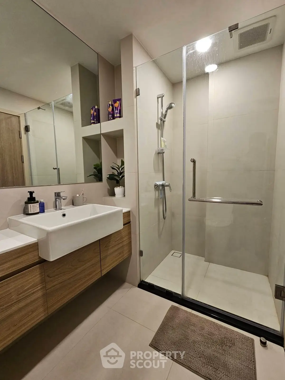Modern bathroom with glass shower and wooden vanity