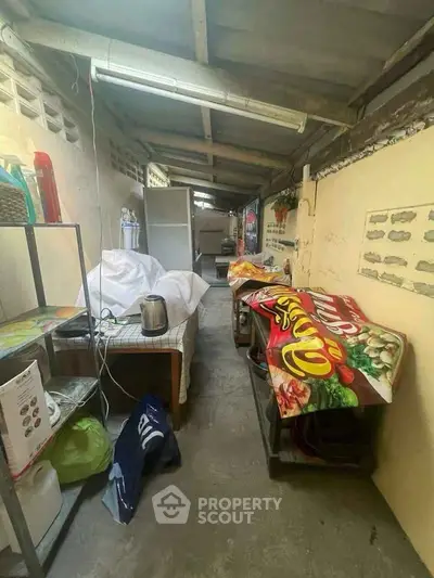 Narrow storage area with shelves and covered items, suitable for organizing household goods.