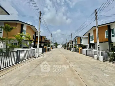 Modern suburban street with contemporary townhouses and clear blue sky.