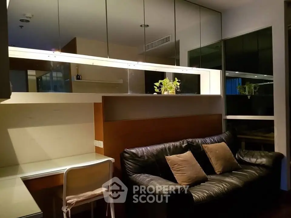 Modern living room with sleek design and cozy black leather sofa