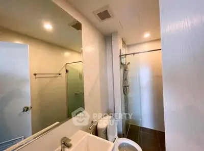 Modern bathroom with glass shower and sleek fixtures in a contemporary home.