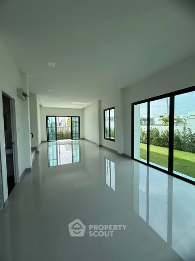 Spacious modern living room with large windows and garden view