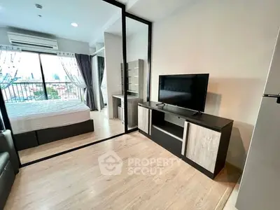 Modern studio apartment with glass partition, sleek furnishings, and city view.