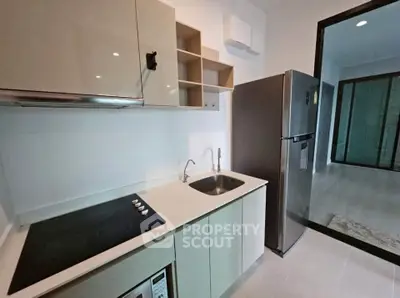 Modern kitchen with sleek cabinetry and stainless steel appliances in a contemporary apartment.