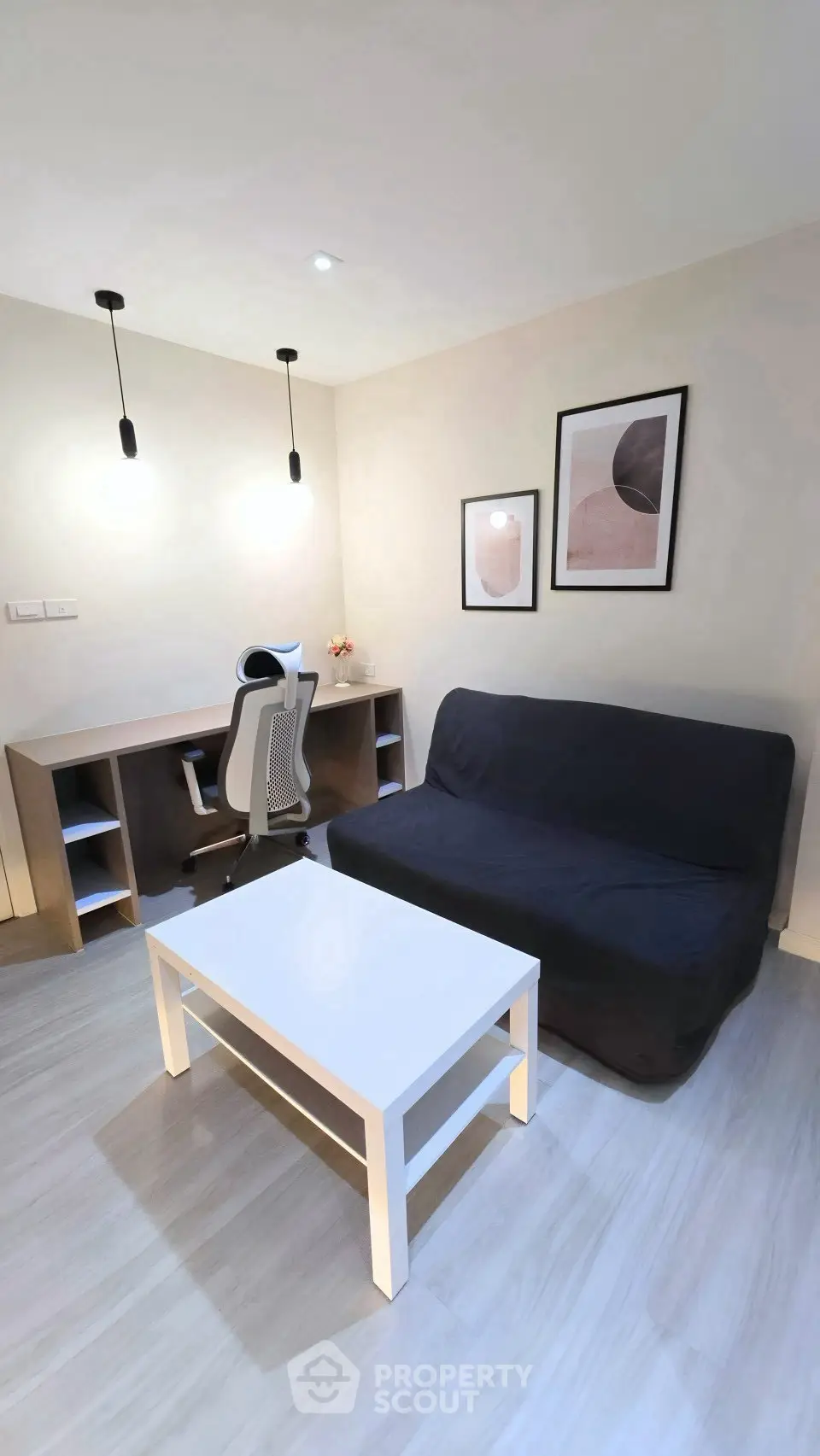 Modern study room with sleek desk, ergonomic chair, and stylish sofa in a cozy apartment.