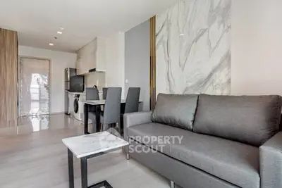Modern living room with stylish marble accents and open kitchen layout