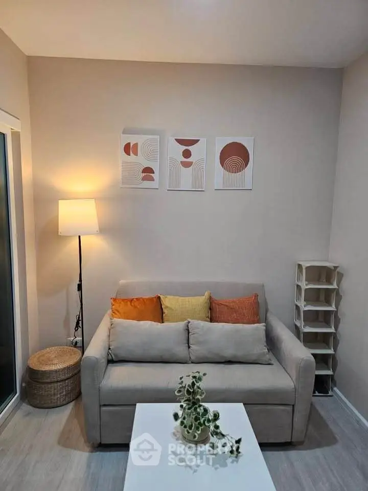 Cozy living room with modern decor, featuring a comfortable sofa, stylish artwork, and ambient lighting.