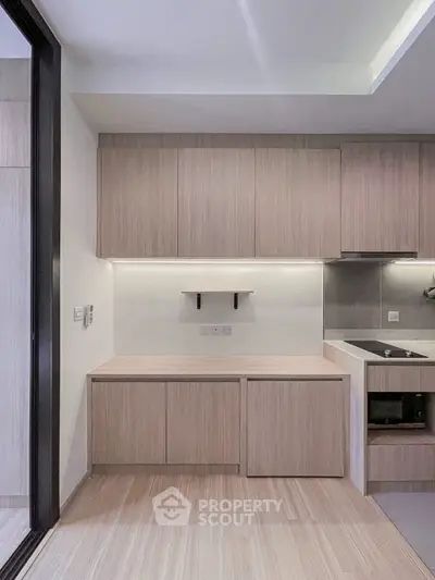Modern kitchen with sleek cabinetry and built-in oven in a contemporary apartment.