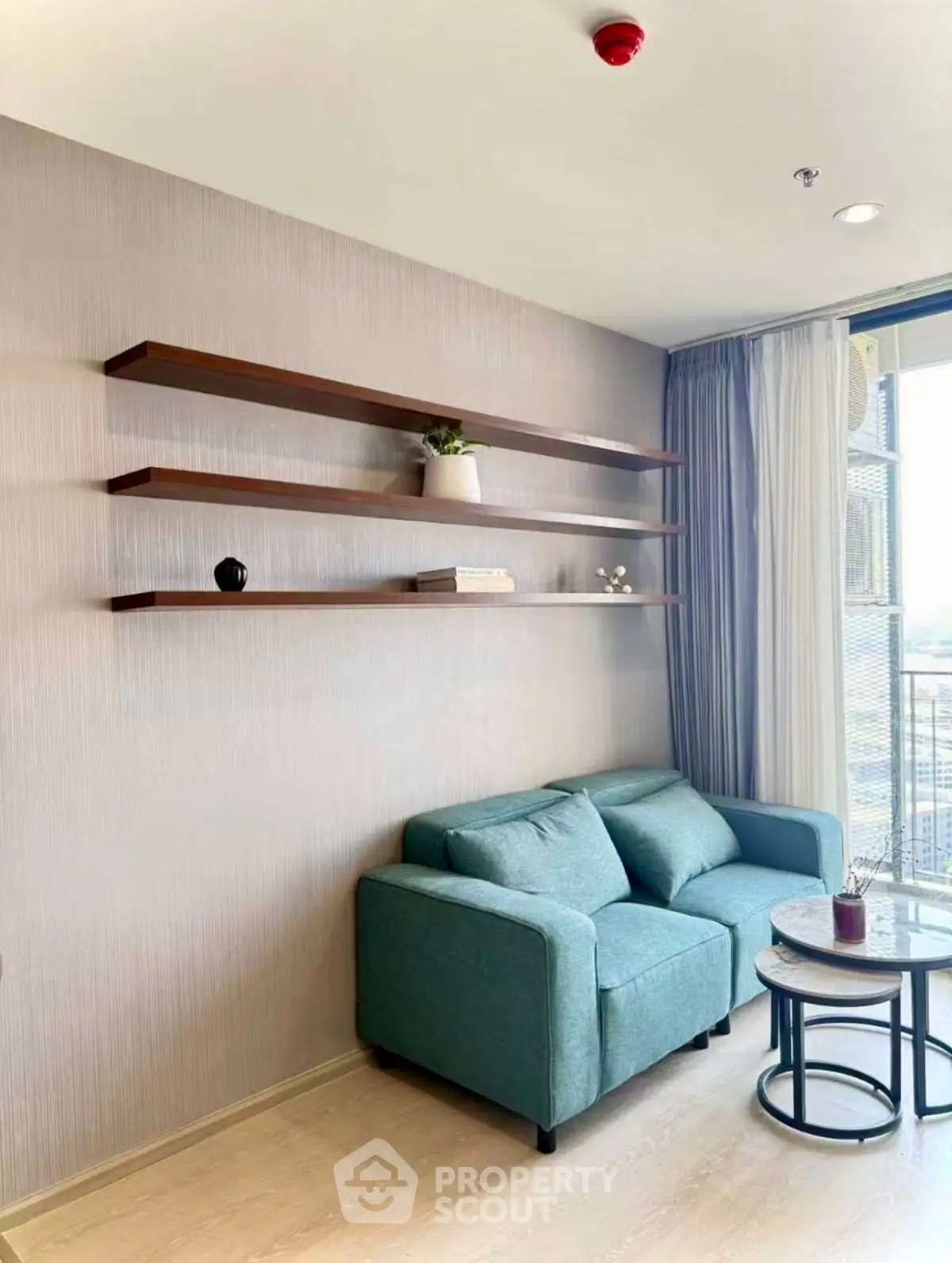 Modern living room with teal sofa and floating shelves, bright natural light