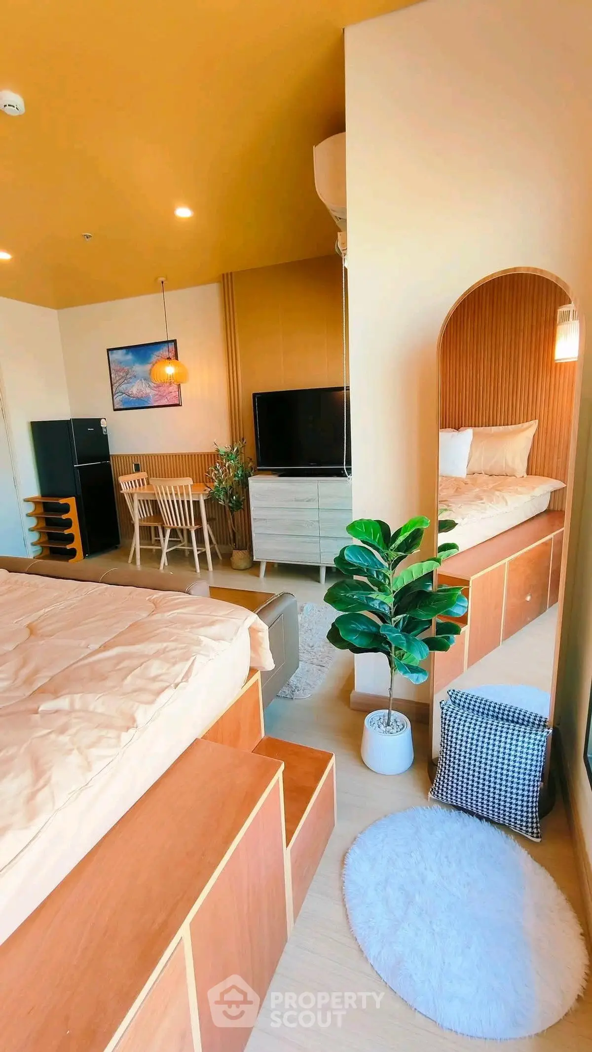 Modern studio apartment with cozy bed, stylish decor, and dining area, perfect for urban living.