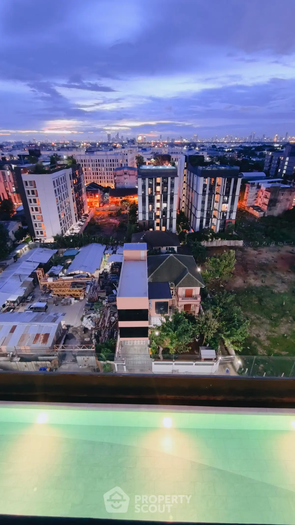 Stunning cityscape view from a high-rise building with a serene pool in the foreground, perfect for urban living.